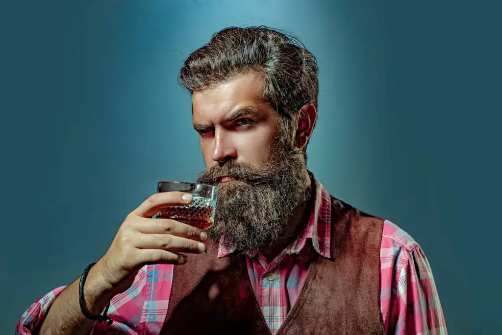 Bearded handsome man holding glass of whiskey. Alcohol concept. Alcohol Drink. Retro vintage man with whiskey or scotch - Can You Drink Alcohol on a Carnivore Diet