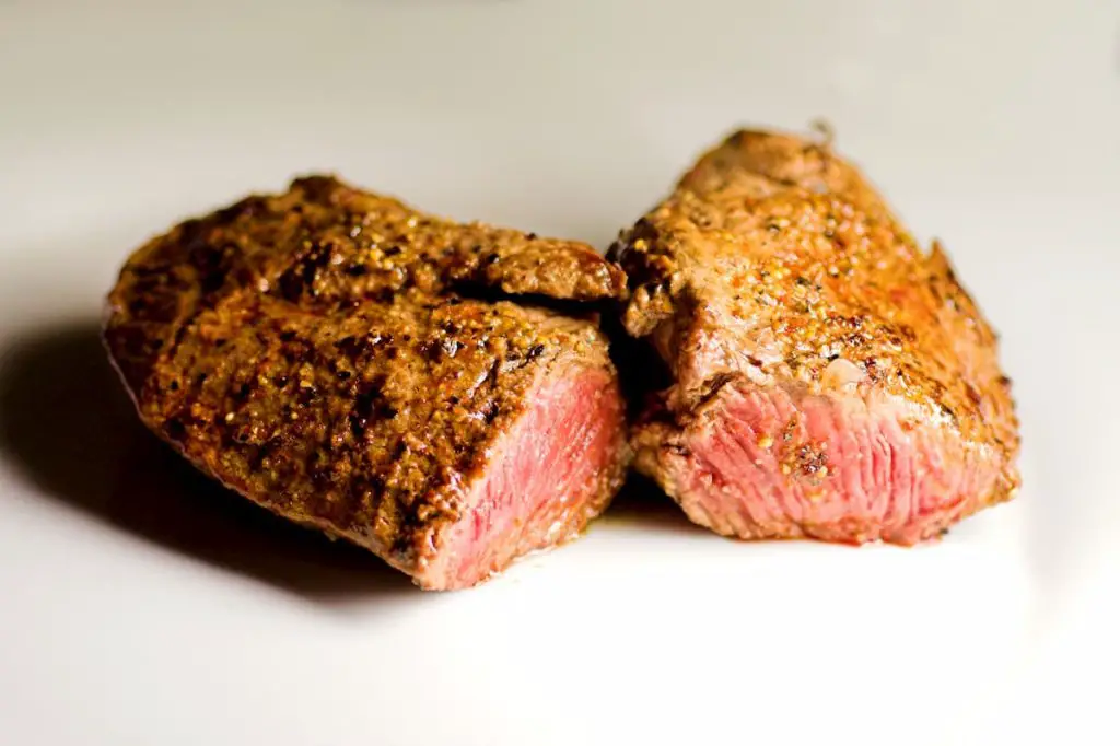 Fried steak with pepper marinade and basil leaf, nicely pink inside  - Benefits Of The Carnivore Diet