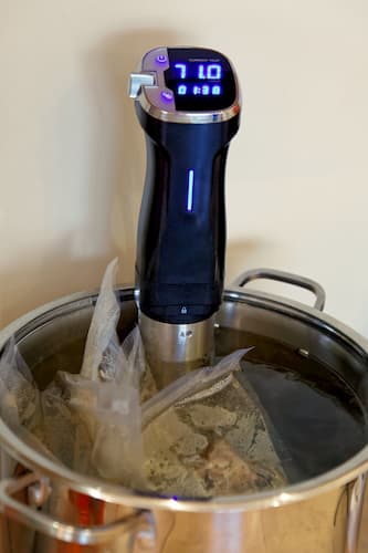 Sous vide cooker in pan with vacuum bag. Thermal immersion circulator for cooking - Carnivore Diet Sous Vide Meat and Steak Cooking