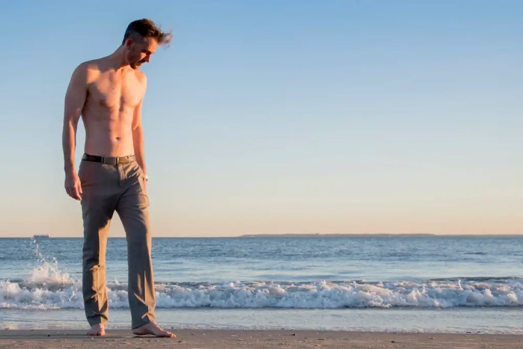 Tall shirtless man walking on an Atlantic beach - Can I Do a Carnivore Diet Long Term